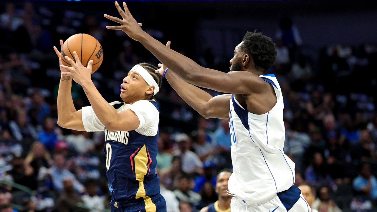 Pelicans guard Jeremiah Fears snatches the ball in midair as Mavericks center Moussa Cisse reaches in from behind.
