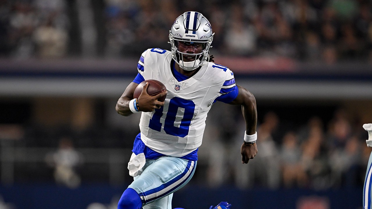 Dallas Cowboys quarterback Joe Milton III runs with the ball tucked under his right arm in a white No. 10 jersey.