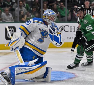 St. Louis Blues goaltender Joel Hofer drops to a knee for a glove save as Dallas Stars right wing Mikko Rantanen watches.