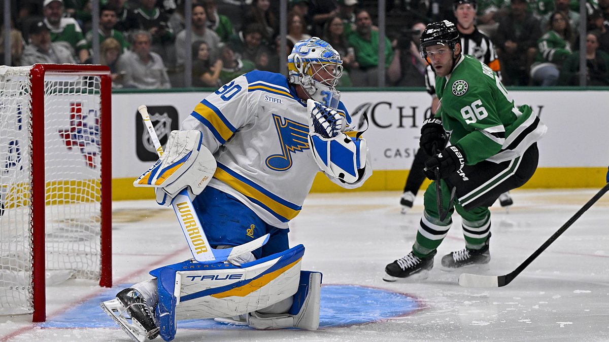St. Louis Blues goaltender Joel Hofer drops to a knee for a glove save as Dallas Stars right wing Mikko Rantanen watches.