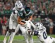 Dallas Cowboys cornerback Joey Porter Jr. and linebacker DeMarvion Overshown drag down Philadelphia Eagles tight end Dallas Goedert.