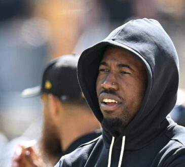 Pittsburgh Steelers cornerback Joey Porter Jr. stands with his arms crossed in a black team hoodie during pregame warm-ups.