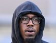 Cornerback Joey Porter Jr., wearing glasses with a black hood pulled over his head, looks on from the field.