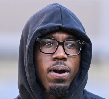 Pittsburgh Steelers cornerback Joey Porter Jr. stands in a hooded team sweatshirt and glasses.