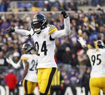 Pittsburgh Steelers cornerback Joey Porter Jr. celebrates in the end zone with one fist raised and the other arm pointing.