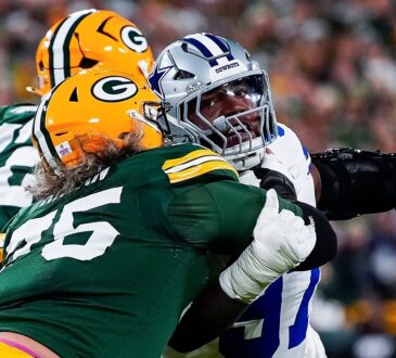 Dallas Cowboys defensive tackle Kenny Clark extends an arm as he battles past a Green Bay Packers lineman.