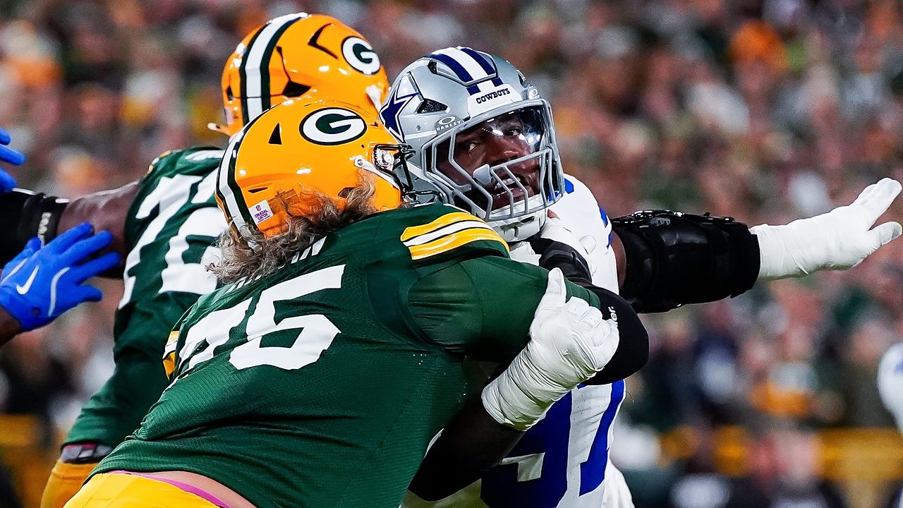 Dallas Cowboys defensive tackle Kenny Clark extends an arm as he battles past a Green Bay Packers lineman.