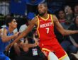 Rockets forward Kevin Durant holds the ball out wide as Mavericks guard Max Christie reaches in to defend.
