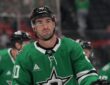 Stars defenseman Kyle Capobianco looks up during a stoppage in play as teammates skate behind him.