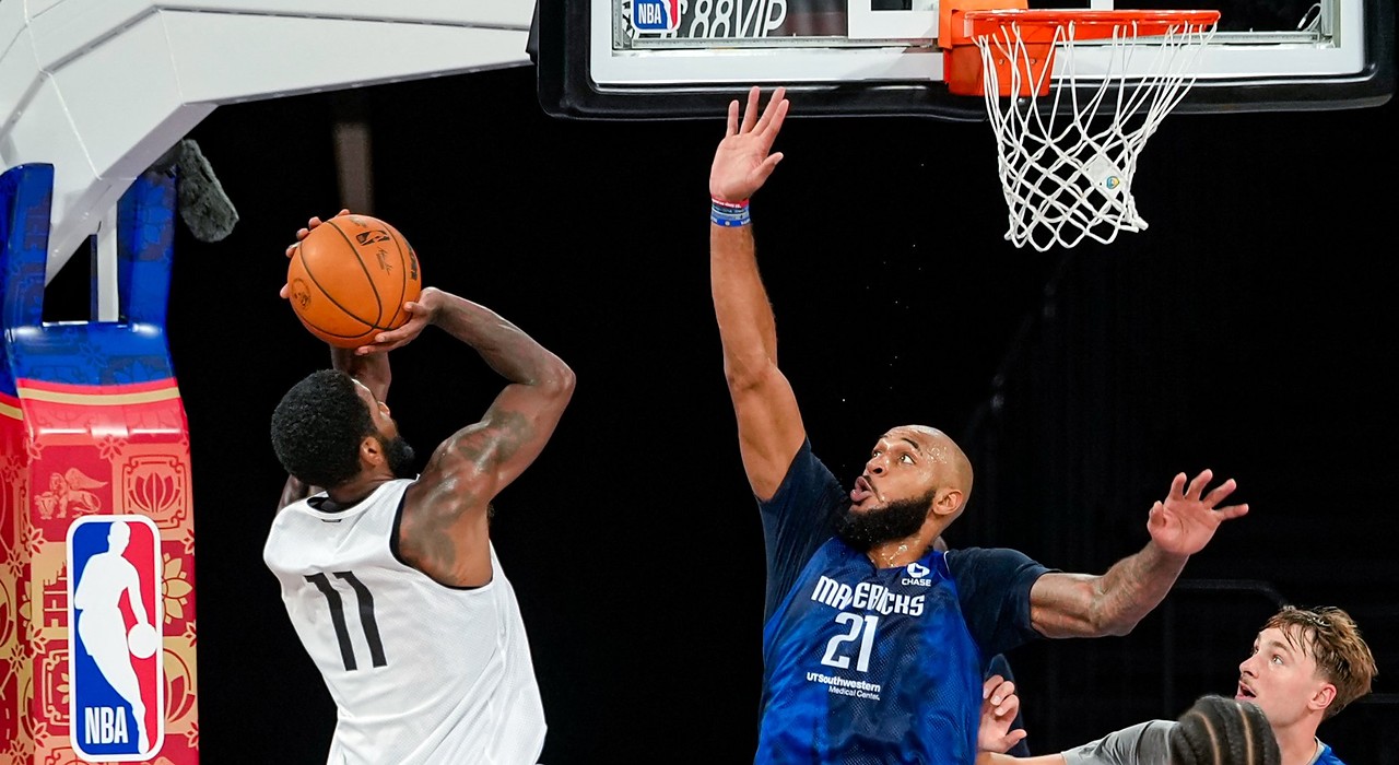 Mavericks guard Kyrie Irving rises for a jump shot as forward Daniel Gafford stretches to contest it at practice.