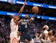 Mavericks guard Kyrie Irving goes up for a layup as Rockets forward Kevin Durant reaches to contest.