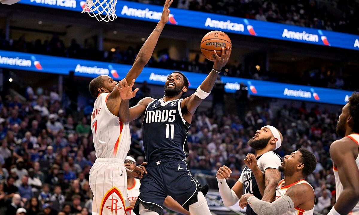 Mavericks guard Kyrie Irving goes up for a layup as Rockets forward Kevin Durant reaches to contest.