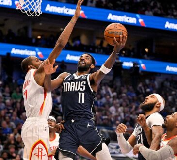 Mavericks guard Kyrie Irving goes up for a layup as Rockets forward Kevin Durant reaches to contest.