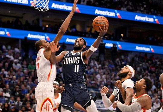 Mavericks guard Kyrie Irving goes up for a layup as Rockets forward Kevin Durant reaches to contest.