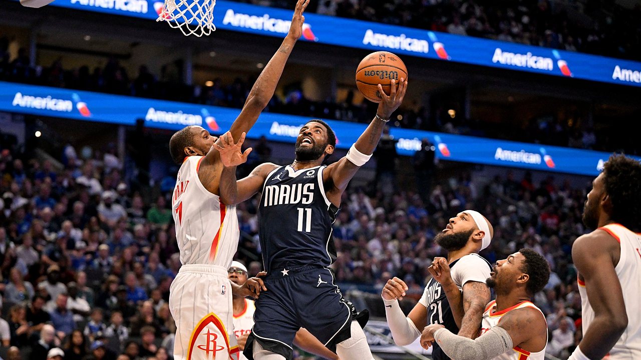 Mavericks guard Kyrie Irving goes up for a layup as Rockets forward Kevin Durant reaches to contest.