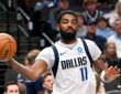 Dallas Mavericks guard Kyrie Irving whips a one-handed pass with his right arm extended during a game.