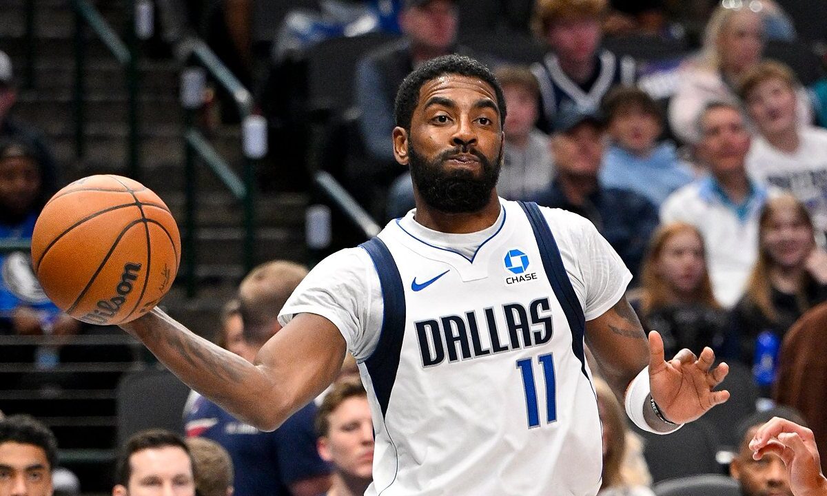 Dallas Mavericks guard Kyrie Irving whips a one-handed pass with his right arm extended during a game.