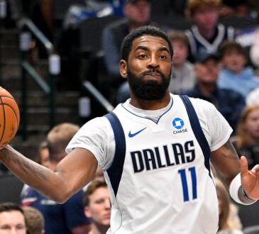 Dallas Mavericks guard Kyrie Irving whips a one-handed pass with his right arm extended during a game.