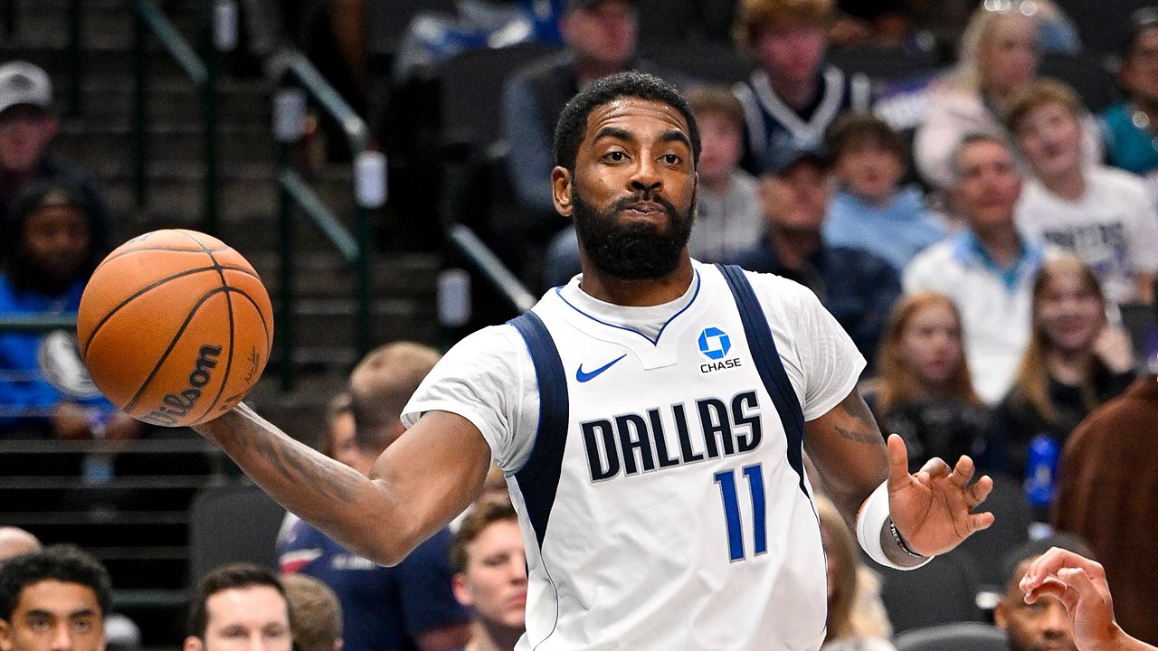 Dallas Mavericks guard Kyrie Irving whips a one-handed pass with his right arm extended during a game.