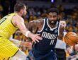 Dallas Mavericks guard Kyrie Irving drives with the ball as Indiana Pacers center Ivica Zubac reaches in to defend.