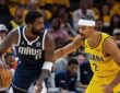 Dallas Mavericks guard Kyrie Irving dribbles low with his right hand as Indiana Pacers guard Andrew Nembhard reaches in to defend.
