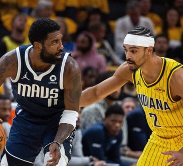 Dallas Mavericks guard Kyrie Irving dribbles low with his right hand as Indiana Pacers guard Andrew Nembhard reaches in to defend.