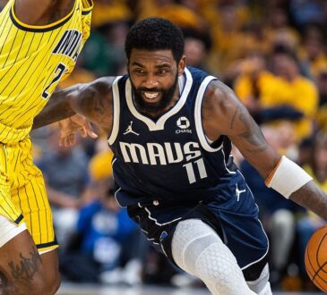Dallas Mavericks guard Kyrie Irving drives low past Indiana Pacers guard Quenton Jackson, who reaches high with one arm.
