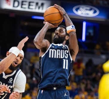 Dallas Mavericks guard Kyrie Irving rises for a jump shot as Indiana Pacers guard Andrew Nembhard reaches past a teammate.