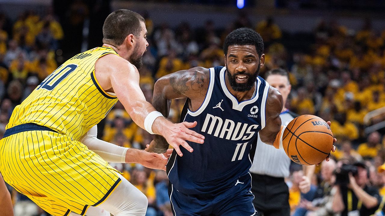 Dallas Mavericks guard Kyrie Irving drives with the ball as Indiana Pacers center Ivica Zubac reaches in to defend.