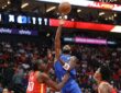 Dallas Mavericks guard Kyrie Irving releases a one-handed shot over Houston Rockets center Clint Capela near the basket.