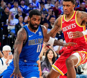 Mavericks guard Kyrie Irving dribbles low as Rockets forward Jabari Smith Jr. defends in front of a packed crowd.