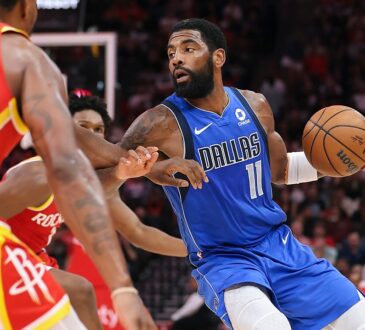Dallas Mavericks guard Kyrie Irving dribbles past Houston Rockets defenders with the ball in his left hand.