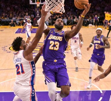 Los Angeles Lakers forward LeBron James #23 drives past Philadelphia 76ers center Joel Embiid #21 at Crypto.com Arena.