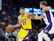 Los Angeles Lakers guard Luka Dončić dribbles with his right hand as Sacramento Kings forward Domantas Sabonis reaches in.