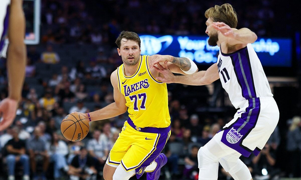 Los Angeles Lakers guard Luka Dončić dribbles with his right hand as Sacramento Kings forward Domantas Sabonis reaches in.