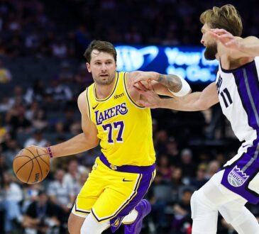 Los Angeles Lakers guard Luka Dončić dribbles with his right hand as Sacramento Kings forward Domantas Sabonis reaches in.