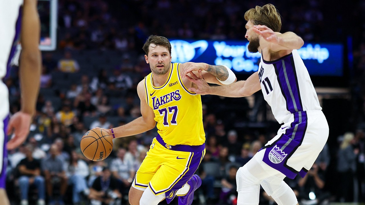 Los Angeles Lakers guard Luka Dončić dribbles with his right hand as Sacramento Kings forward Domantas Sabonis reaches in.