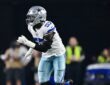 Dallas Cowboys linebacker Malachi Lawrence charges forward off the edge with his hands up during a play.