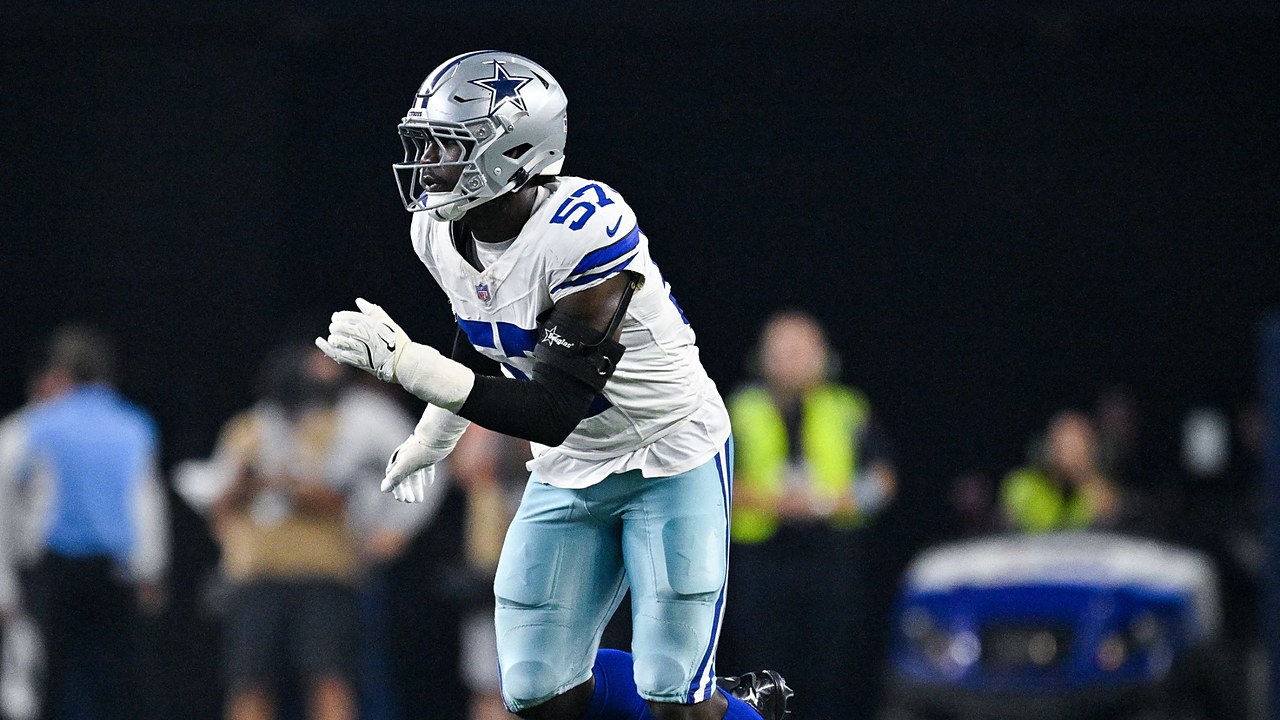 Dallas Cowboys linebacker Malachi Lawrence charges forward off the edge with his hands up during a play.