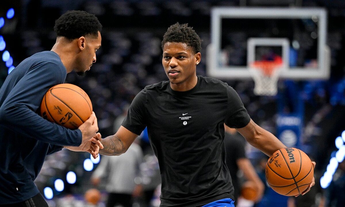 Dallas Mavericks guard Marcus Sasser dribbles during warmups in a black Mavericks T-shirt as a staff member works with him.
