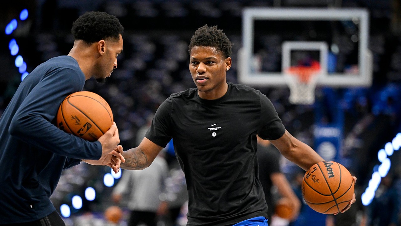Dallas Mavericks guard Marcus Sasser dribbles during warmups in a black Mavericks T-shirt as a staff member works with him.