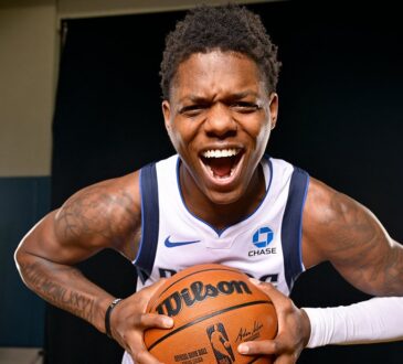 Dallas Mavericks guard Marcus Sasser yells and leans toward the camera while gripping a basketball with both hands.
