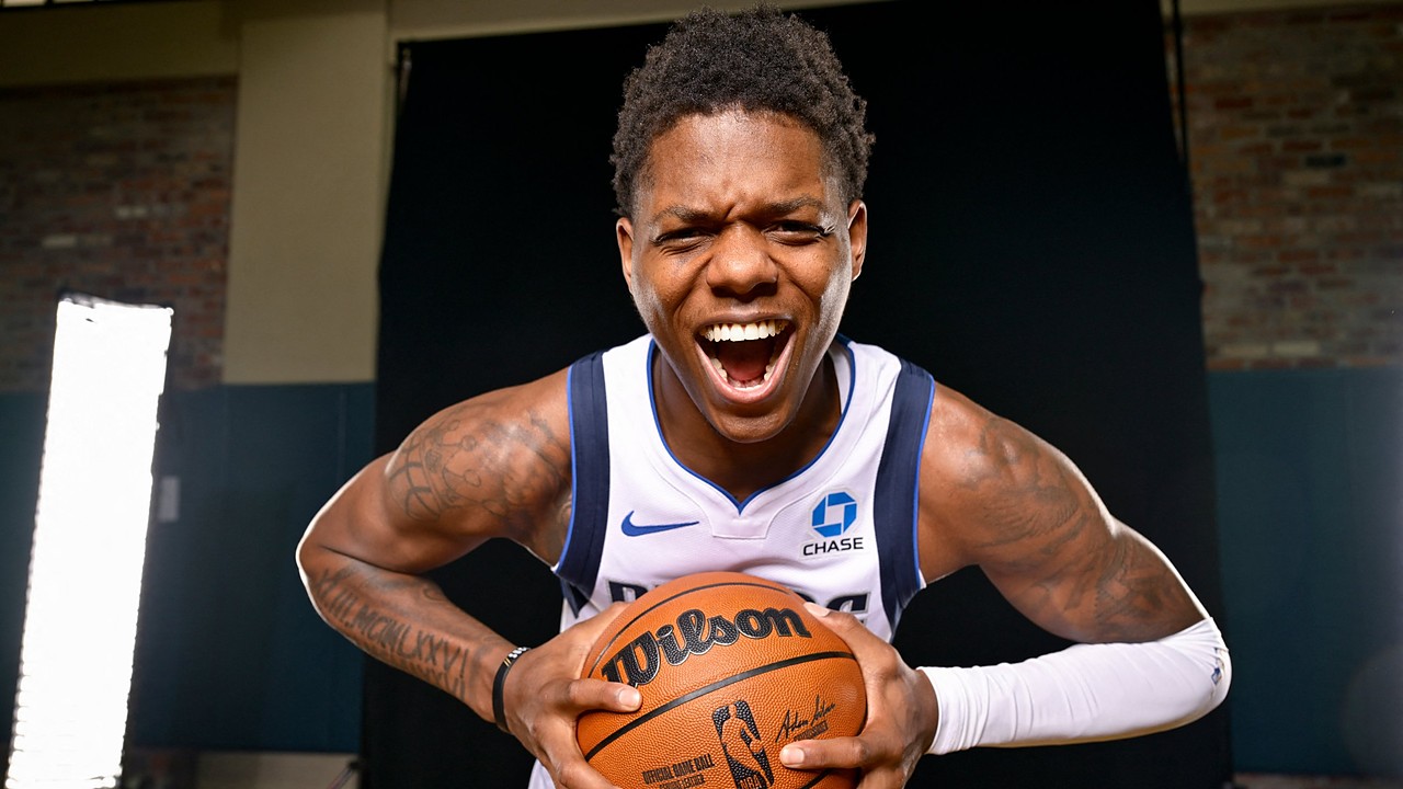Dallas Mavericks guard Marcus Sasser yells and leans toward the camera while gripping a basketball with both hands.
