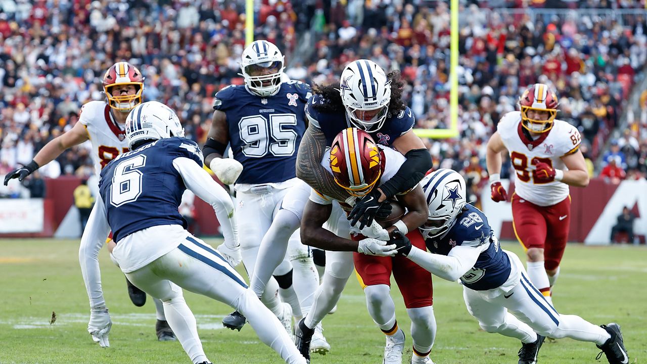 Dallas Cowboys linebacker Marist Liufau and safety Malik Hooker wrap up Washington Commanders running back Jacory Croskey-Merritt.