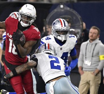 Arizona Cardinals wide receiver Marvin Harrison Jr. carries the ball as Dallas Cowboys safety Juanyeh Thomas reaches to tackle.