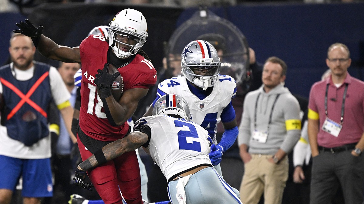 Arizona Cardinals wide receiver Marvin Harrison Jr. carries the ball as Dallas Cowboys safety Juanyeh Thomas reaches to tackle.