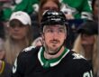 Stars center Matt Duchene, in the team's black alternate jersey, glances over his shoulder with fans behind the glass.