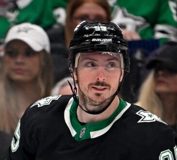 Stars center Matt Duchene, in the team's black alternate jersey, glances over his shoulder with fans behind the glass.