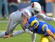 Los Angeles Rams quarterback Matthew Stafford falls forward as Arizona Cardinals linebacker Josh Sweat reaches over him.