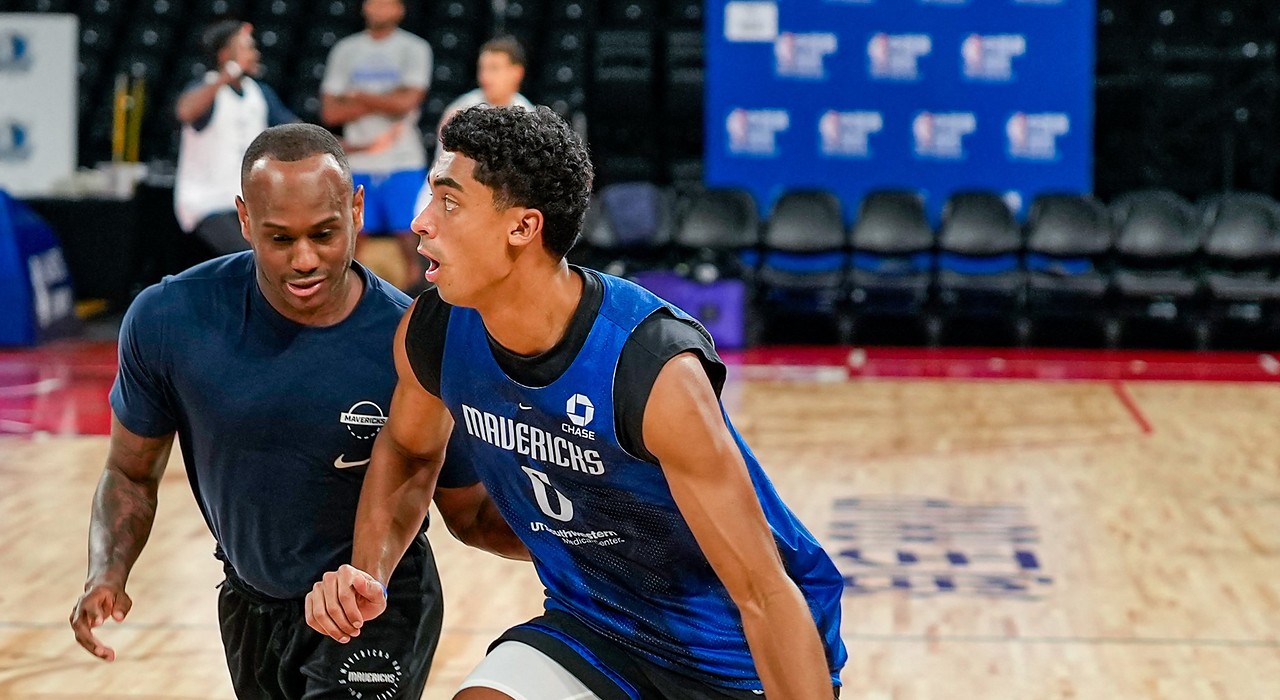 Mavericks guard Max Christie dribbles past a staff member defending him during practice.